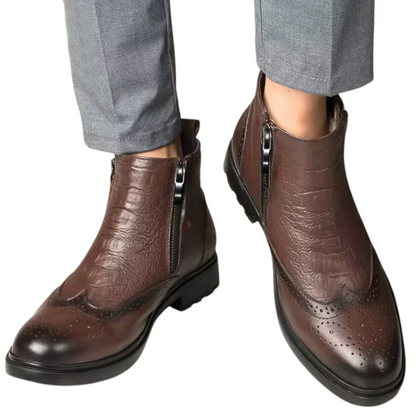 Brown leather boots with zippers worn with gray pants on a white background