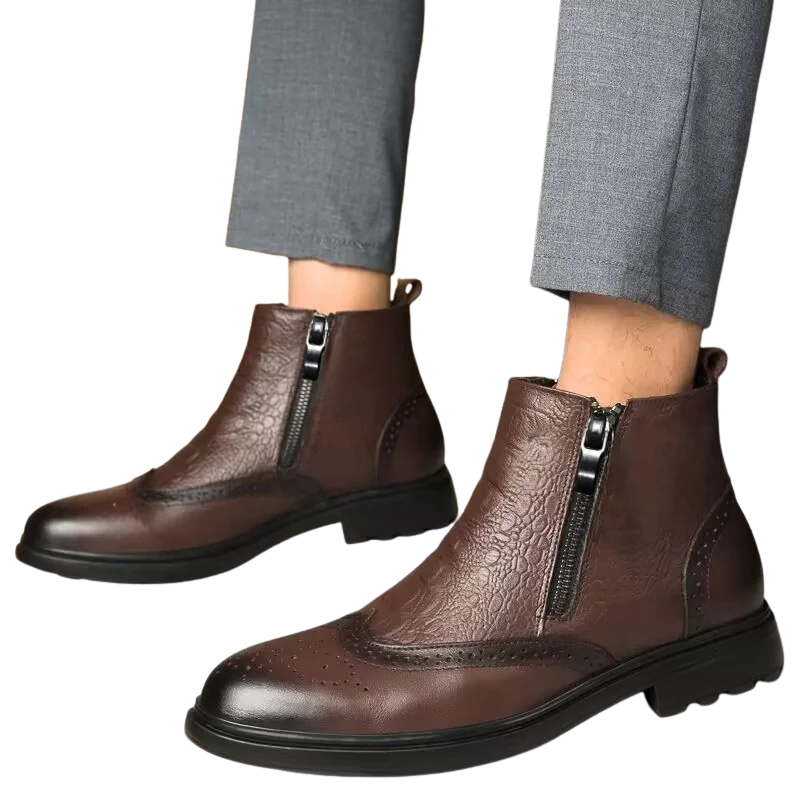 Brown leather boots with zippers worn with gray pants on a white background