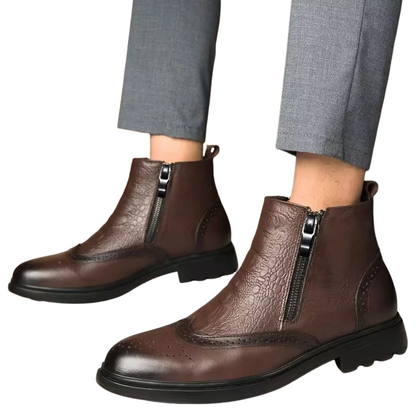 Brown leather boots with zippers worn with gray pants on a white background