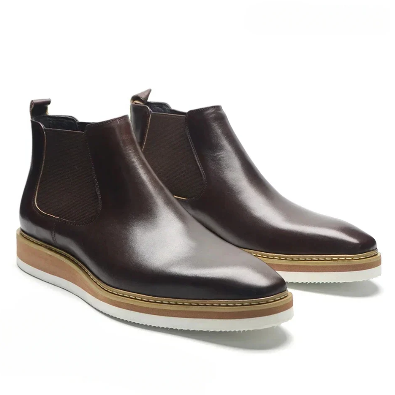 Pair of brown leather Chelsea boots on a white background