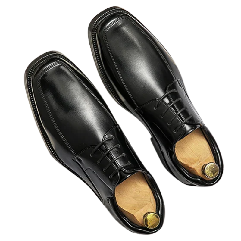 Pair of black dress shoes with wooden soles on a white background