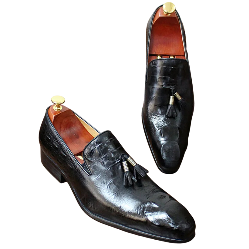 Pair of black leather loafers with tassels on a white background