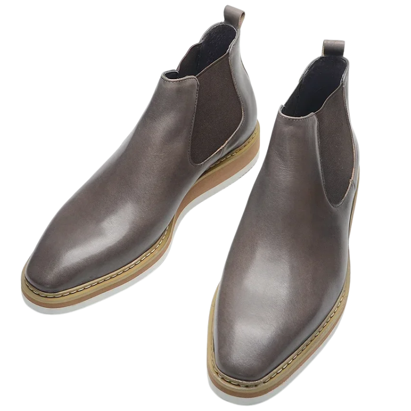 Pair of brown leather Chelsea boots on a white background