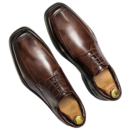 Pair of brown leather dress shoes on a white background