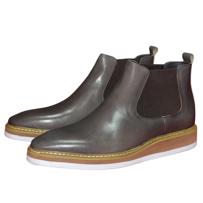 Pair of brown leather Chelsea boots on a white background