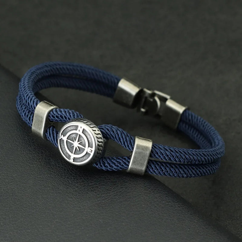 Blue braided bracelet with a silver compass charm