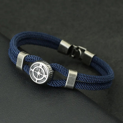 Blue braided bracelet with a silver compass charm