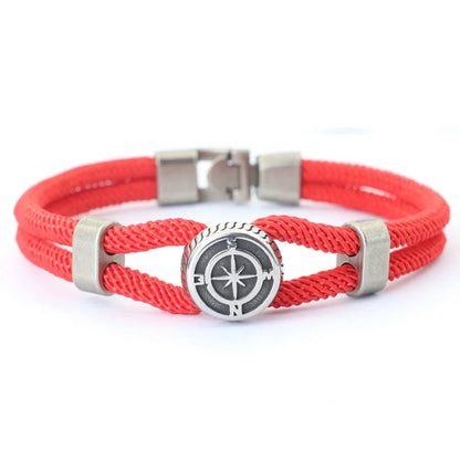 Red braided bracelet with a silver compass charm